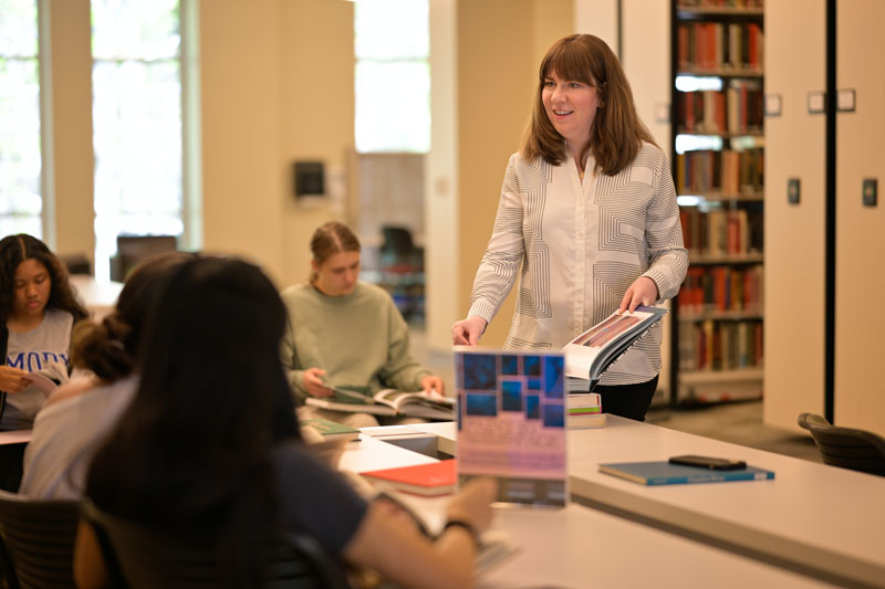 Mary Johnson sharing books of paintings with her students