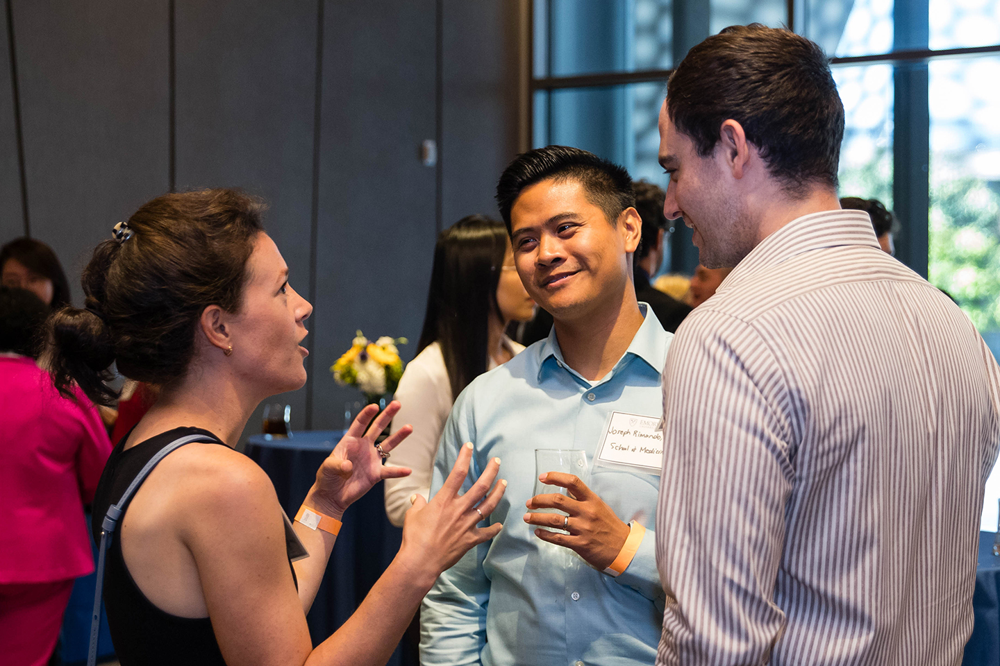 Three new faculty members conversing with one another